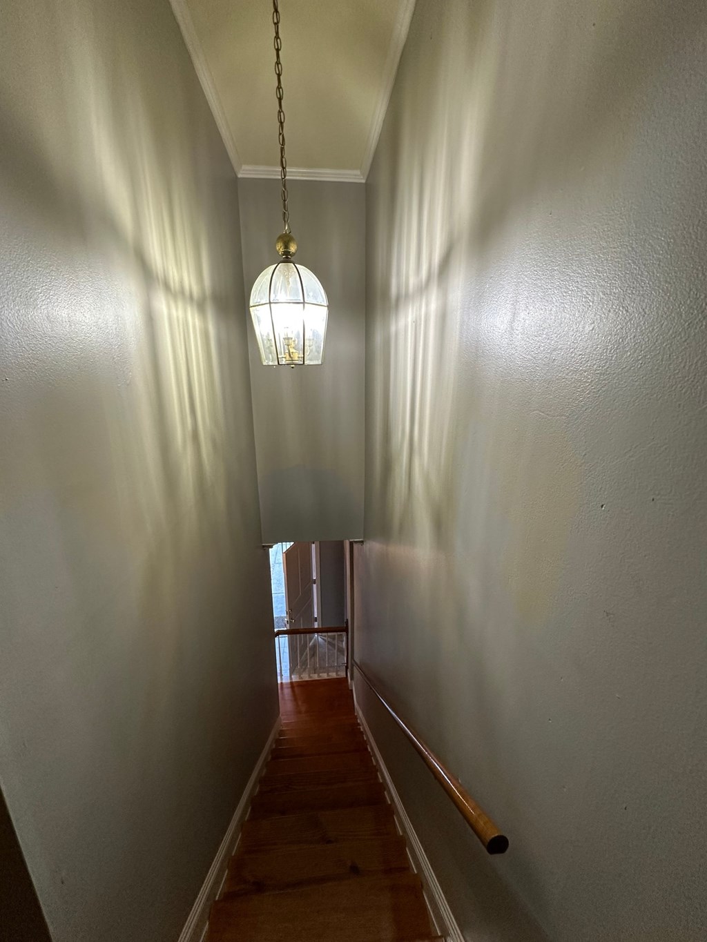 A long hallway with a light hanging from the ceiling.