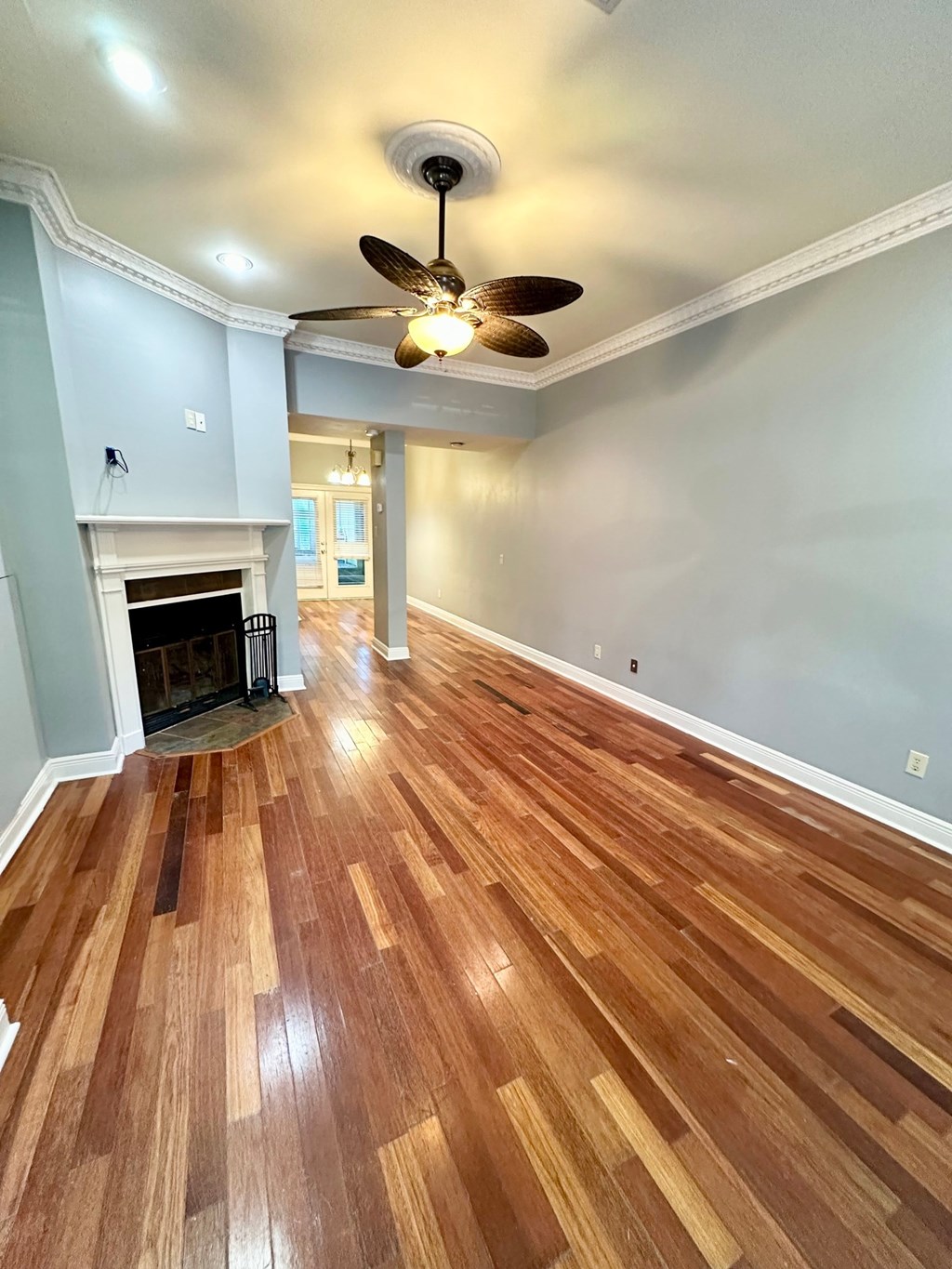 A room with a fireplace and wood flooring.