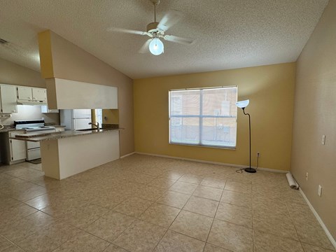 A room with a ceiling fan and a window with blinds.