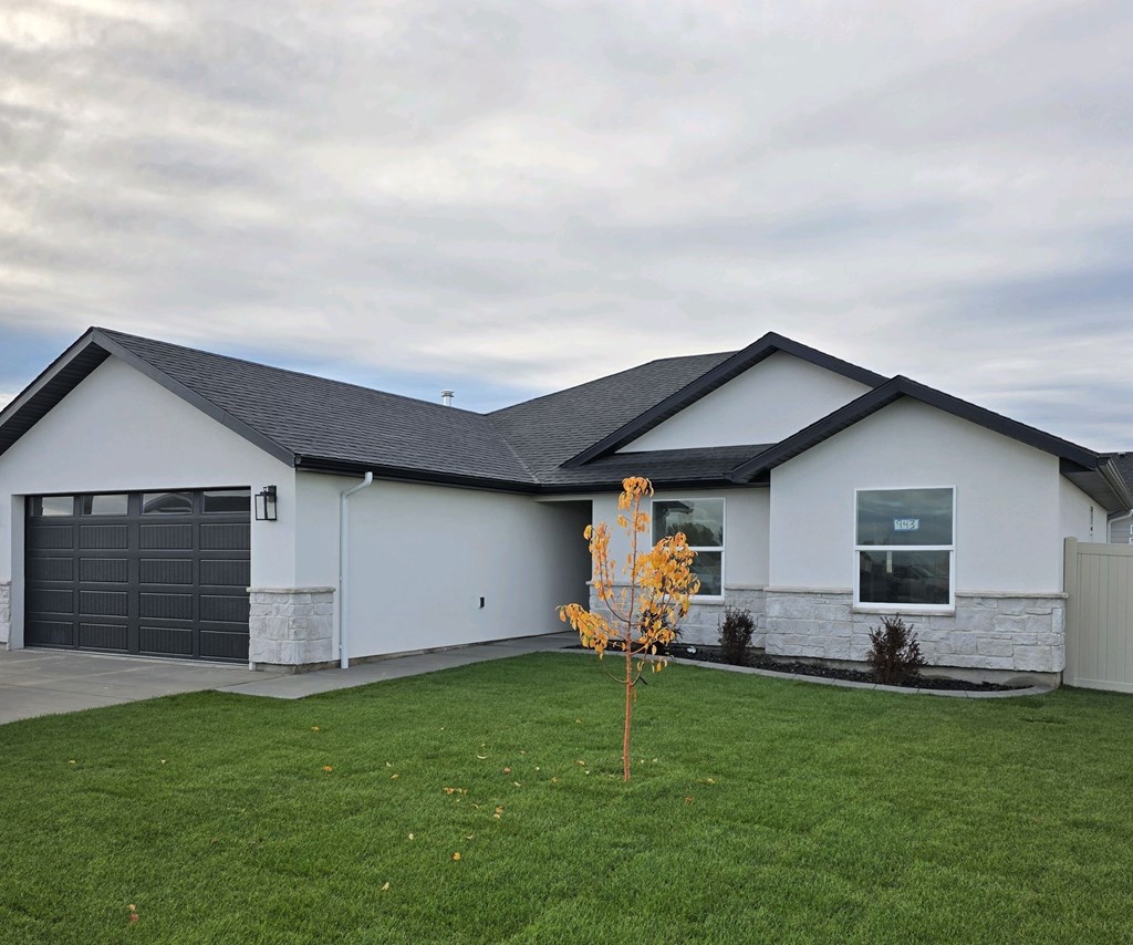 A house with a grey garage door and a grey roof.