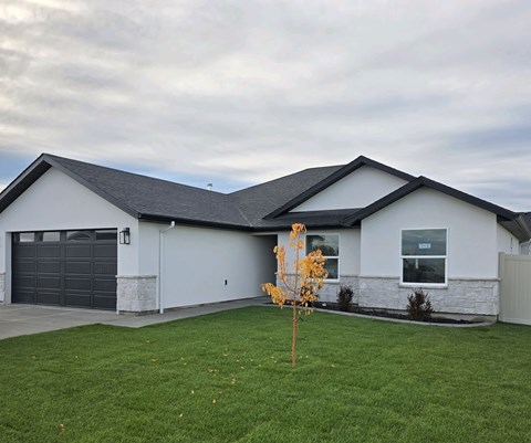 A house with a grey garage door and a grey roof.