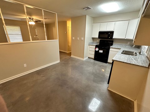 A kitchen with a black stove top oven and white cabinets.