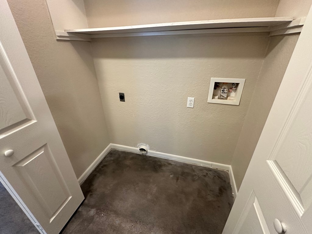 A small room with a white door and a picture on the wall.