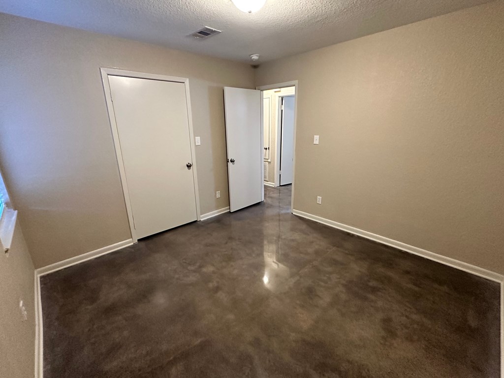 A room with a brown floor and white walls.