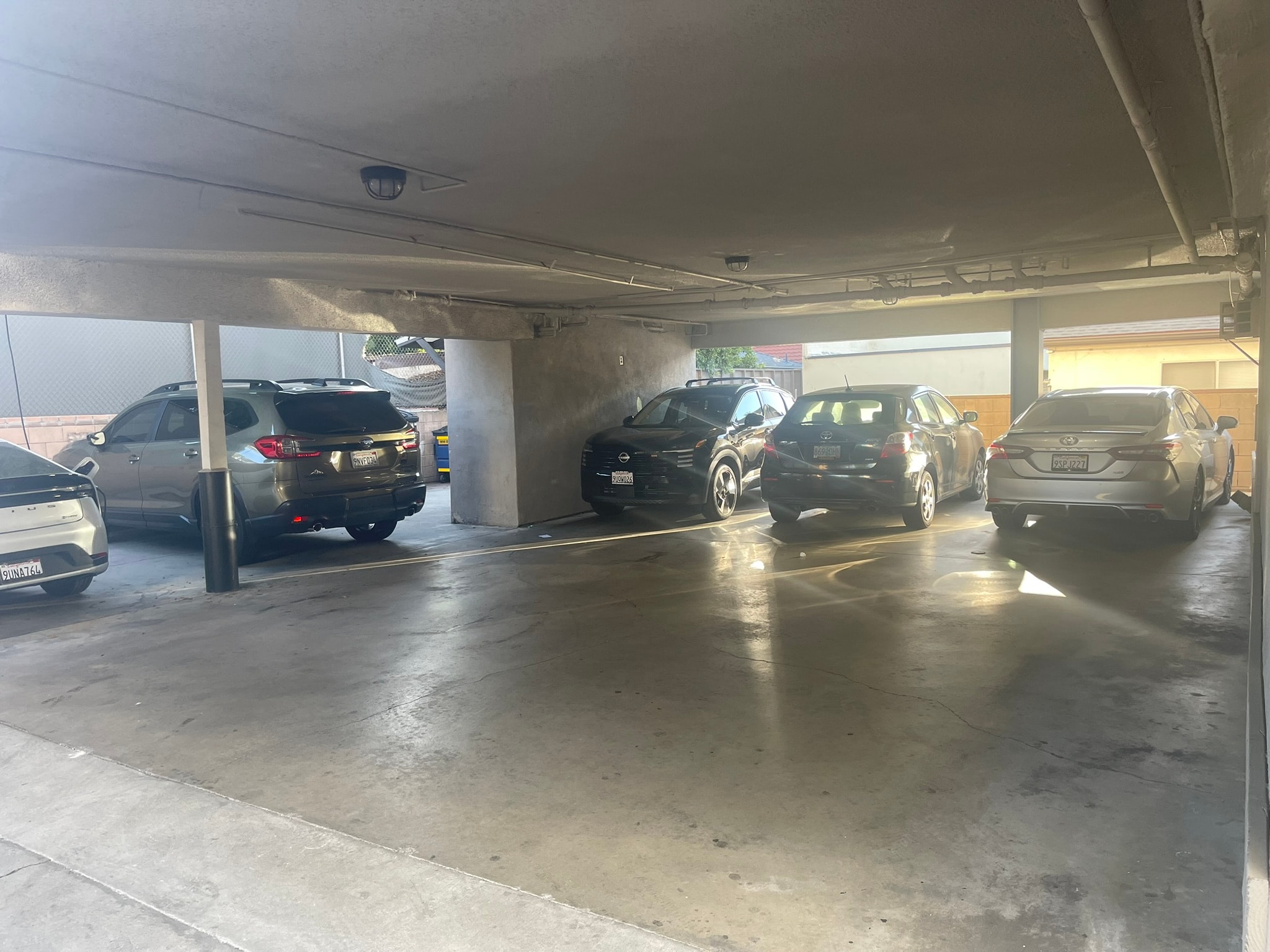 A parking garage with several cars parked in it.