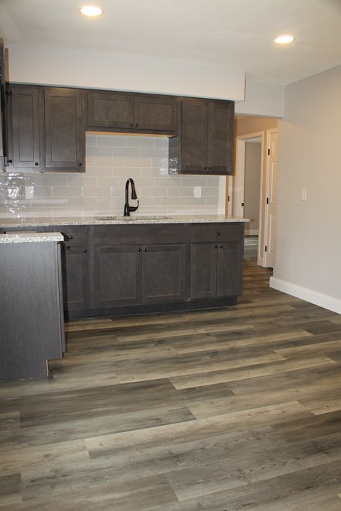 A kitchen with wooden cabinets and a grey countertop.