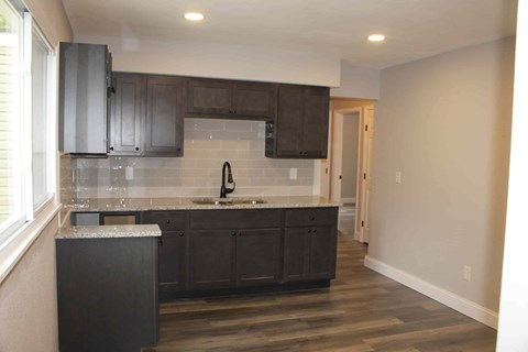 A kitchen with dark wood cabinets and a white countertop.