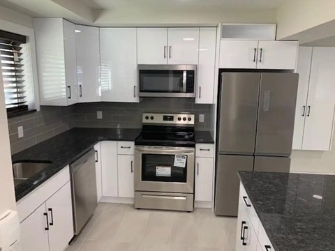 A modern kitchen with stainless steel appliances and white cabinets.