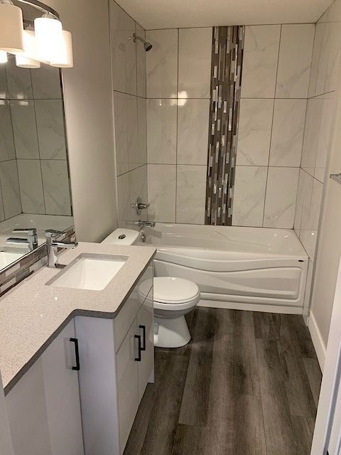 A white bathroom with a white toilet, sink, and tub.