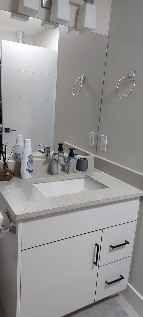 A white bathroom with a sink and a mirror.