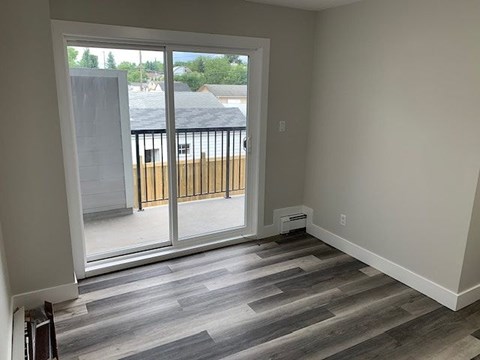 A room with a sliding glass door leading to a balcony.
