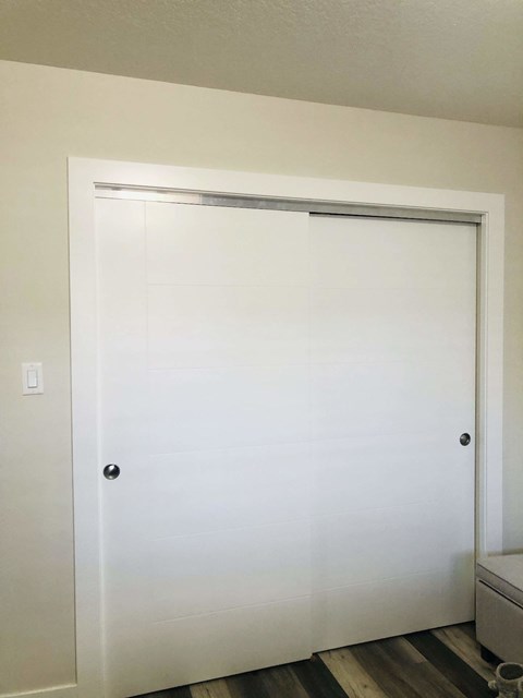 A white door with a black handle and a silver lock.
