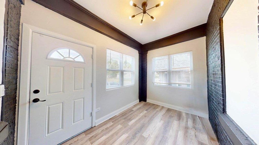 A white door with a window above it and a wooden floor.