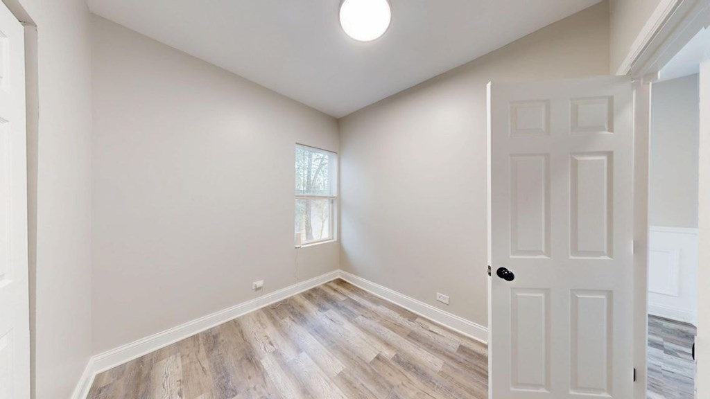 A room with a white door and a window with a white frame.