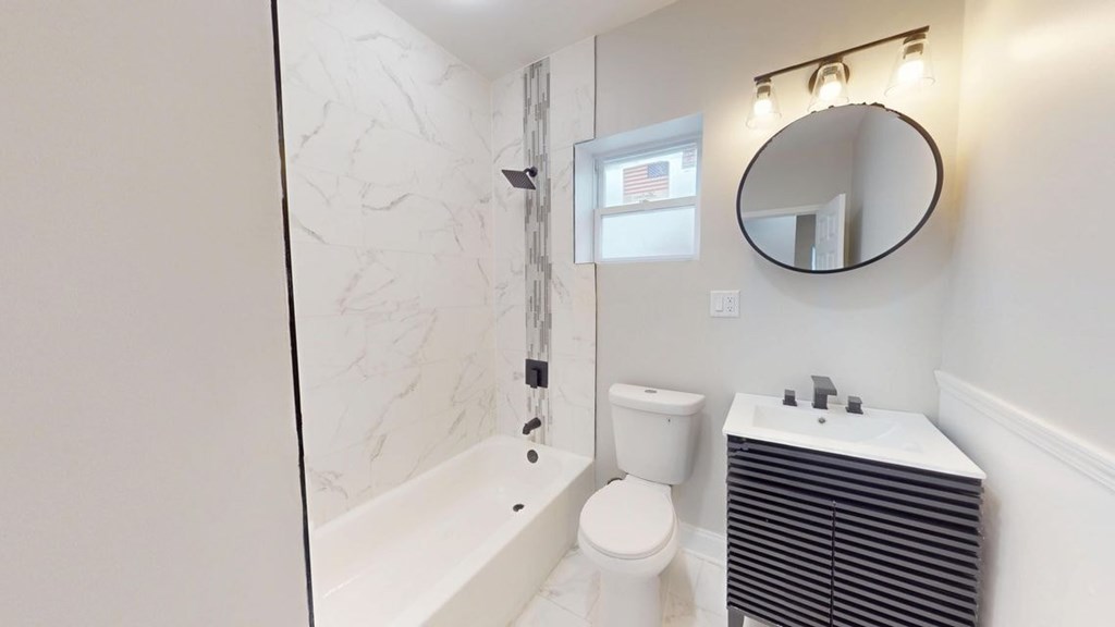 A bathroom with a white toilet, a white sink, and a white bathtub.