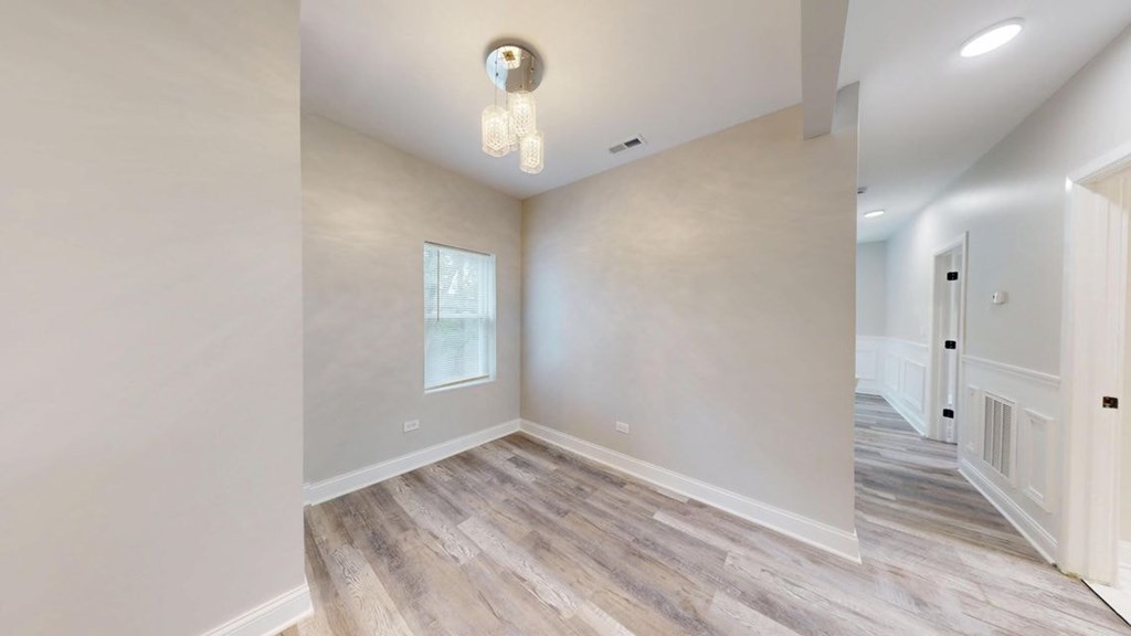 A room with a light on the ceiling and a door on the right.