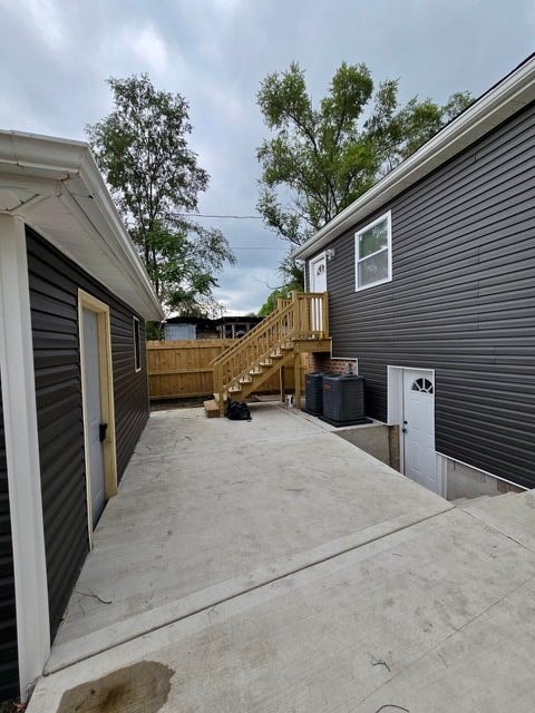 A grey house with a white door and a small window.