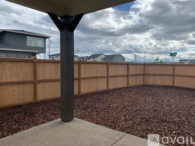 A patio with a table and chairs is surrounded by a wooden fence.