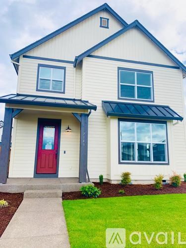A house with a red door and a brown roof.
