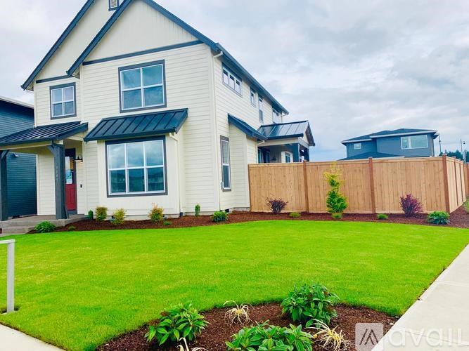 A modern house with a well-maintained lawn in front.