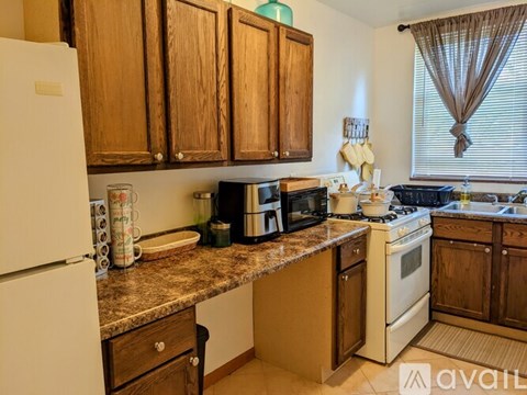 A kitchen with wooden cabinets and a granite countertop.