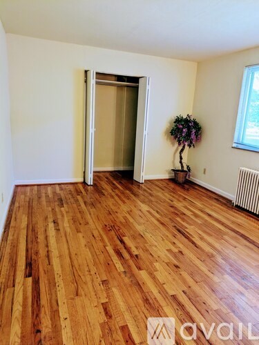 A room with wooden flooring and a doorway leading to another room.
