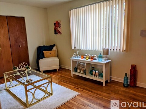 A room with a glass table and a shelf with bottles on it.