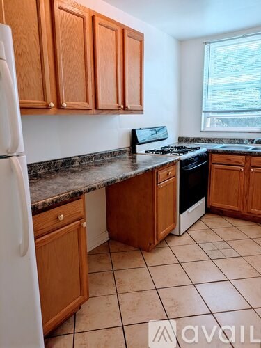 A kitchen with wooden cabinets and a white refrigerator.