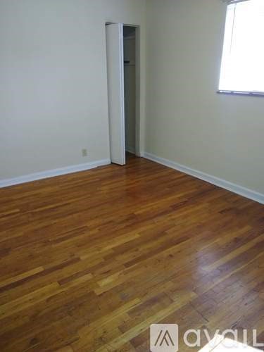 A room with wooden flooring and a white wall.