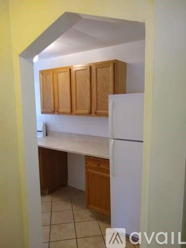 A kitchen with wooden cabinets and a white refrigerator.