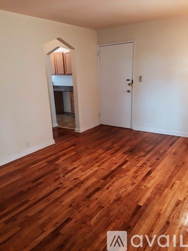 A room with wooden flooring and a white door.