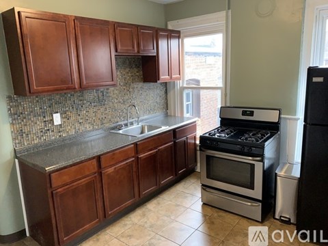 A kitchen with brown cabinets and a black stove.