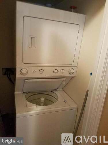A white washing machine with a door open and water in the bottom.