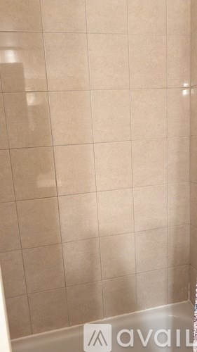 A bathroom with beige tiles and a sign that says "available".