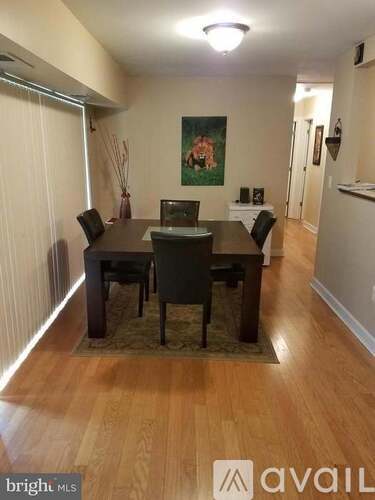 A dining room with a wooden table and chairs.