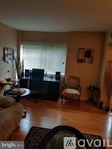 A living room with a couch, chair, and television.