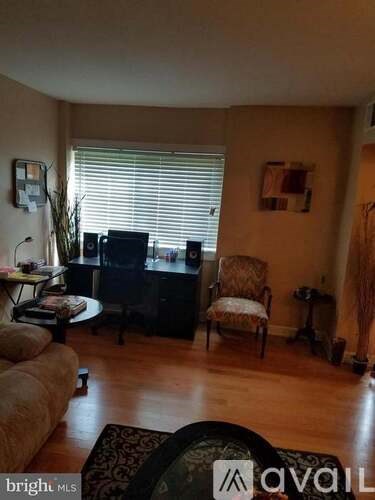 A living room with a couch, chair, and television.