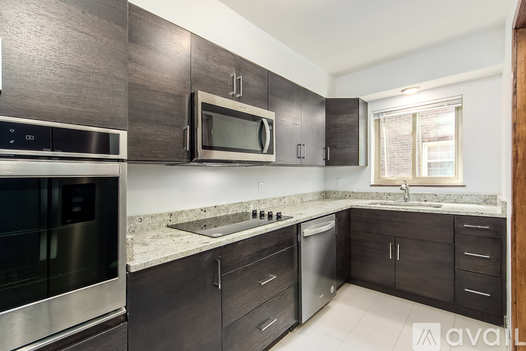 A kitchen with dark wood cabinets and stainless steel appliances.