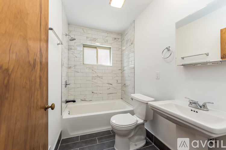 A bathroom with a toilet, sink, and bathtub.