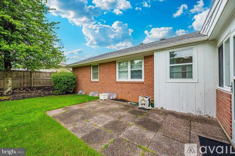 A house with a red brick exterior and a white door is for sale.