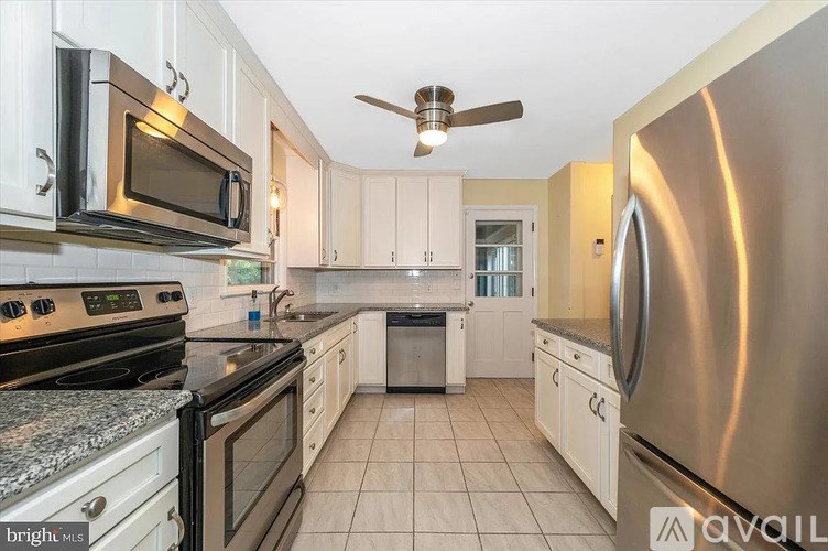 A kitchen with white cabinets and stainless steel appliances.