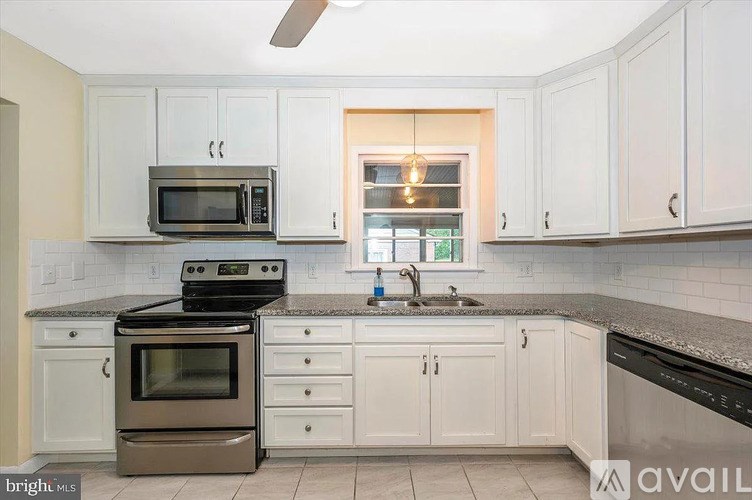 A kitchen with white cabinets and a black stove top oven.