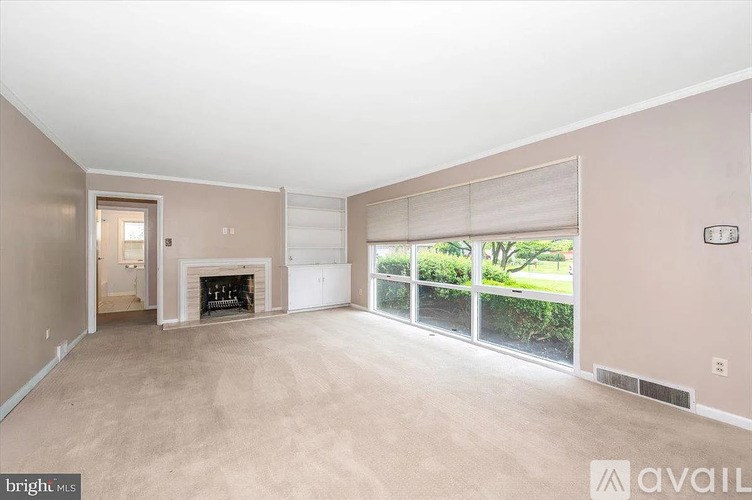 A spacious living room with a fireplace and sliding glass doors.