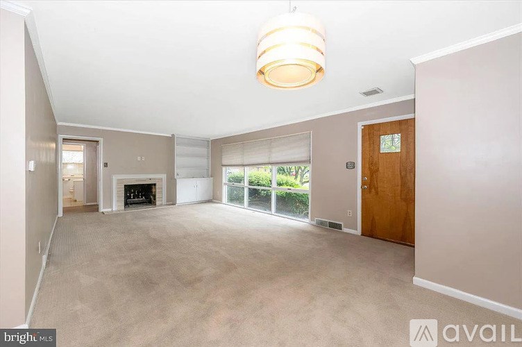 A spacious living room with a fireplace and sliding glass doors.