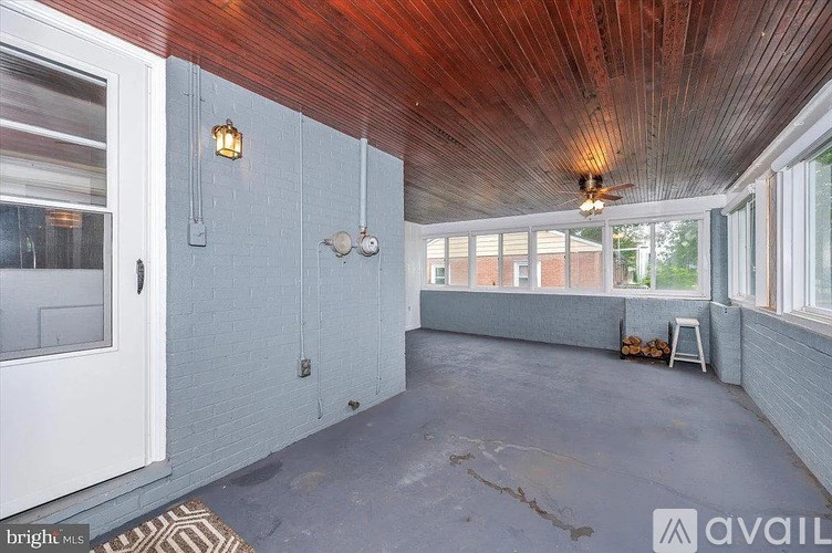 A room with a wooden ceiling and a window on the right side.