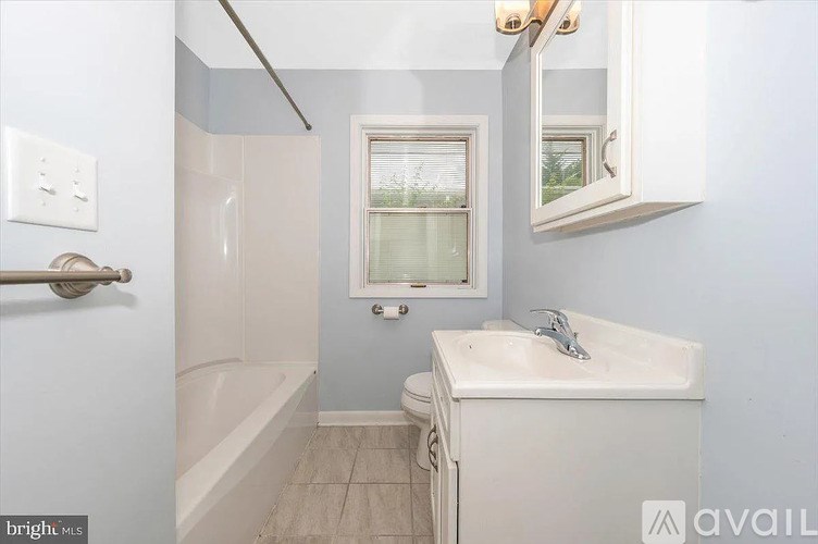 A bathroom with a white sink and a window.