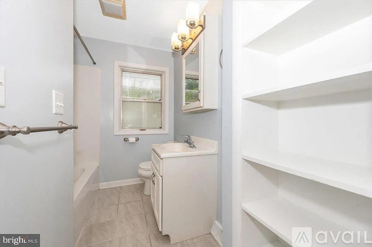 A small bathroom with a toilet, sink, and a window.