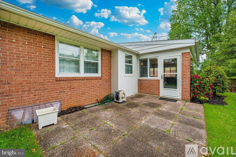 A small brick house with a white door and windows.