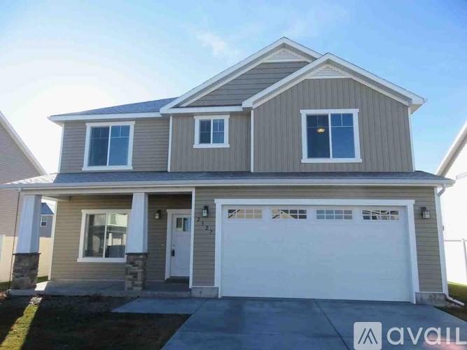 A two-story house with a garage is for sale.