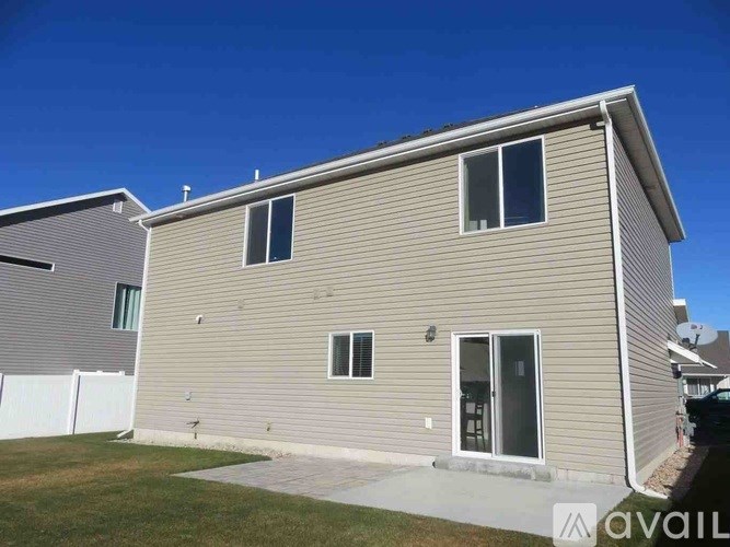 A house with a beige exterior and a white fence is for sale.